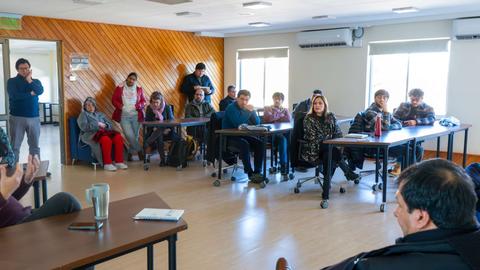 Un grupo de personas escucha atentamente a un orador en una sala de reuniones.