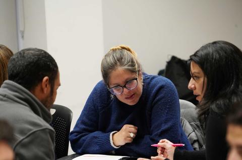 Un grupo de personas se encuentra conversando y trabajando en equipo en un ambiente colaborativo.