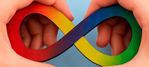 Un símbolo de infinito colorido sostenido entre dos manos.