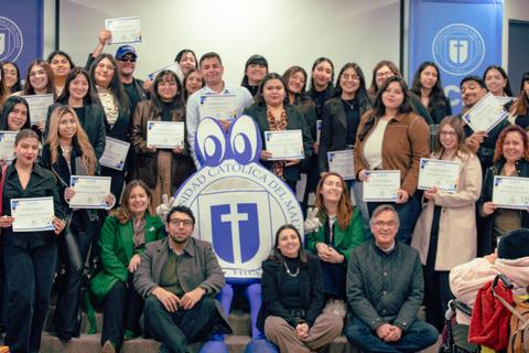 Un grupo de personas sonrientes sosteniendo certificados en un evento de graduación en la Universidad Católica del Maule.
