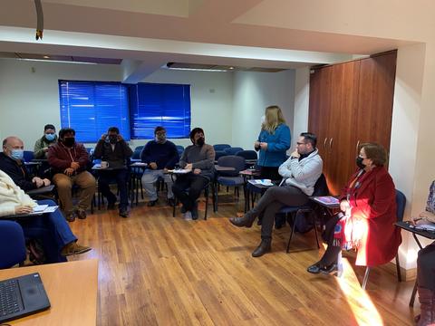 Un grupo de personas sentadas en una sala durante una reunión.