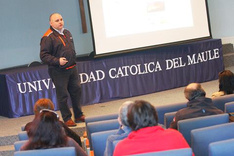 Un hombre presenta una charla en un auditorio de la Universidad Católica del Maule.