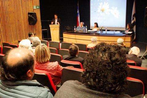 Un grupo de personas asistiendo a una conferencia en un auditorio.