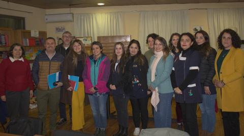 Un grupo de personas posa juntas en una sala con libros y un ambiente acogedor.