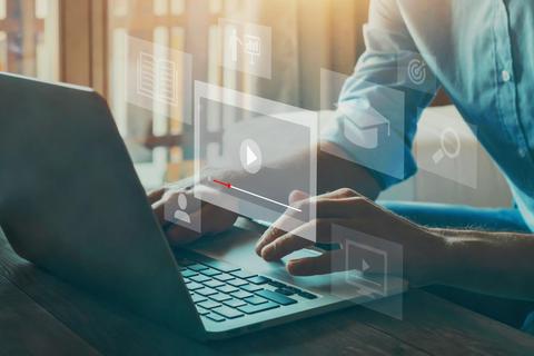 Una persona está usando una computadora portátil mientras interactúa con gráficos digitales que flotan sobre la pantalla.