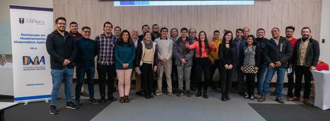 Un grupo de personas posando en un evento educativo en un aula.