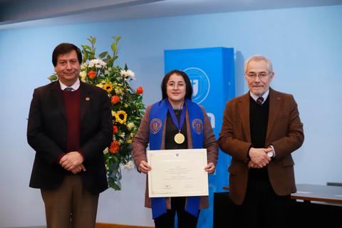 Una estudiante recibe su reconocimiento académicos en una ceremonia oficial.