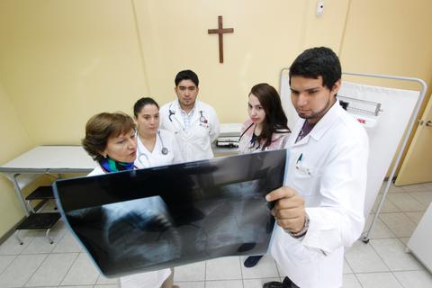Un grupo de médicos observa una radiografía en un consultorio médico.