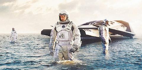 Un grupo de astronautas camina sobre el agua junto a una nave espacial.