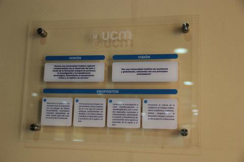 Una placa informativa que presenta la misión, visión y propósitos de una universidad.