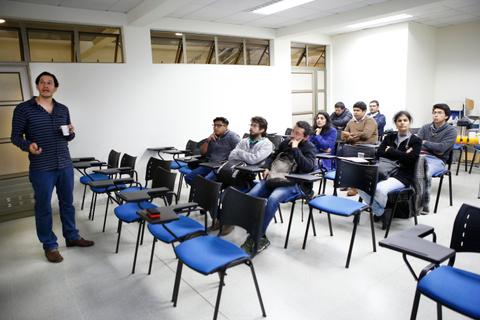 Una persona presenta a un grupo de estudiantes en un salón de clases.
