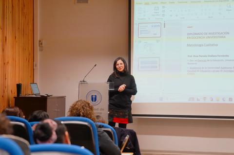 Una profesora está presentando un diplomado en una sala de clases.