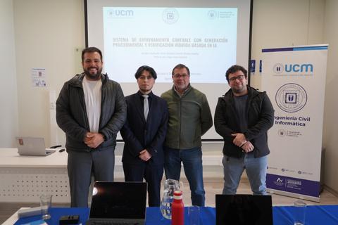 Cuatro hombres posando frente a una presentación en un evento académico en una institución de educación superior.