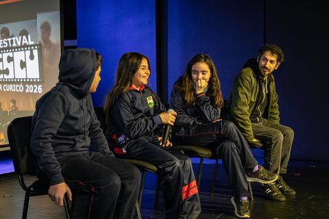 Un grupo de niños y un adulto conversan en un festival en Curicó.