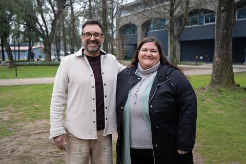 Dos personas sonrientes posando en un parque.