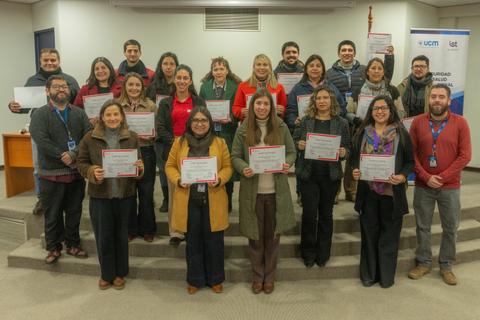 Grupo de personas posando con certificados en un evento en Chile.