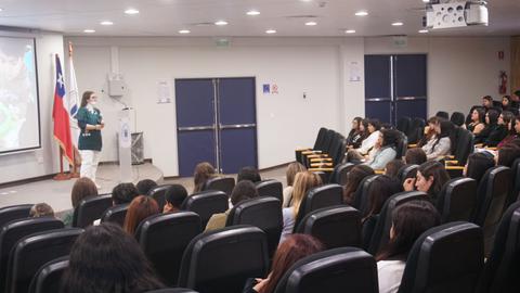 Una charla en Chile con un presentador frente a un público interesado.