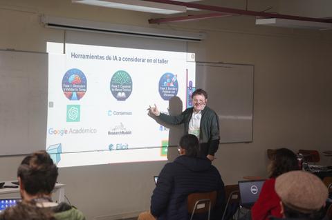 Un profesor explica sobre herramientas de inteligencia artificial en un taller educativo.