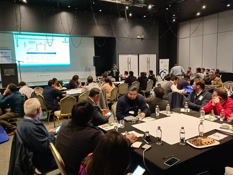 Una reunión con numerosos participantes en un salón de conferencias.