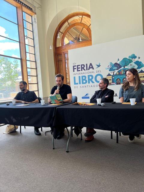 Una mesa de discusión en la Feria Internacional del Libro de Santiago con cuatro participantes, dos hombres y dos mujeres.