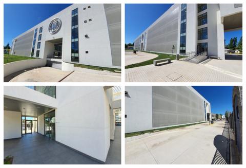 La imagen muestra un edificio moderno con un diseño arquitectónico minimalista y amplias áreas exteriores.