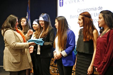Una ceremonia de entrega de becas con varias asistentes en un escenario.