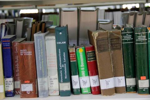 Estantería con una variedad de libros de diferentes géneros y tamaños.