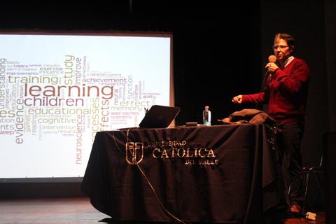 Un ponente habla frente a una presentación sobre aprendizaje y educación.