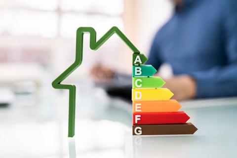Una representación gráfica de la calificación energética de un edificio con forma de casa y etiquetas de A a G.