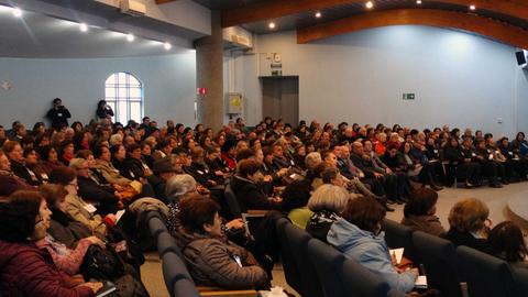 Un gran grupo de personas sentadas en un auditorio durante un evento.