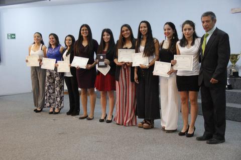 Un grupo de mujeres y un hombre posan en un evento de entrega de certificados.