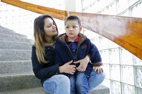 Una madre y su hijo pequeño están sentados en una escalera.