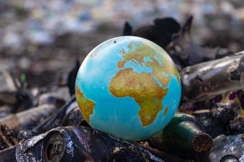 Un globo terráqueo sobre un fondo de basura.