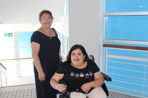 Una mujer y una joven con discapacidad se encuentran en un espacio luminoso y moderno.