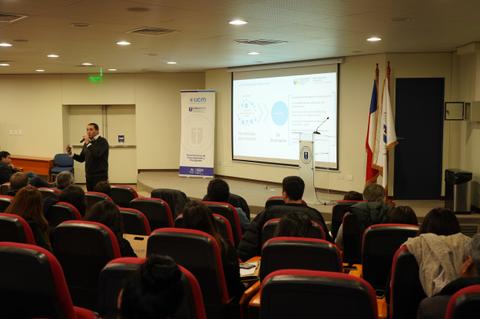Una sala de conferencias con una audiencia atendiendo a una presentación.