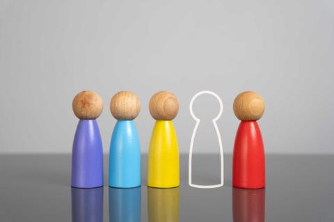 Un grupo de figuras de madera de colores con una figura vacía al medio.