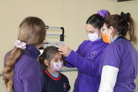 Un grupo de personas está realizando un chequeo de salud a una niña en un ambiente de atención médica.
