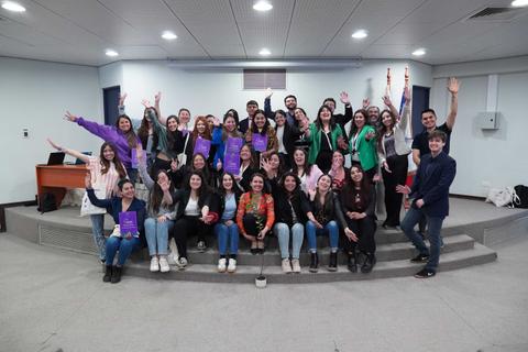 Un grupo de personas sonrientes posando juntas en un evento, mostrando orgullo y alegría.
