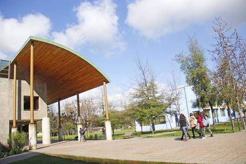 Una vista de un edificio moderno con un gran techo de madera y personas caminando en un espacio abierto.