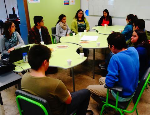 Un grupo de personas sentadas alrededor de una mesa, conversando en un ambiente acogedor.