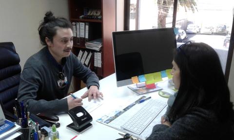 Una persona está conversando y tomando notas en una oficina.