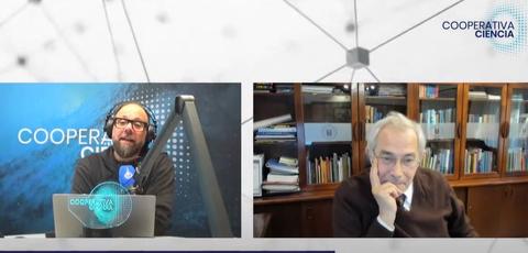 Dos hombres conversando en un programa de televisión sobre ciencia.