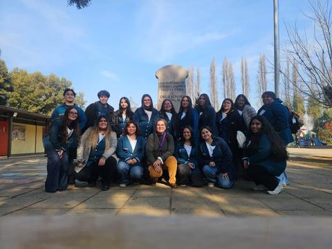 Un grupo de jóvenes posando frente a un monumento en un parque.