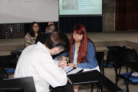 Un grupo de personas interactuando en un aula durante una actividad de aprendizaje.