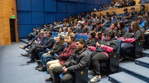 Una multitud de personas sentadas en un auditorio durante un evento.