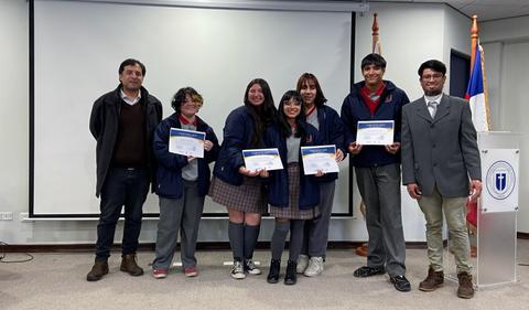 Grupo de estudiantes recibiendo certificados en un evento educativo.