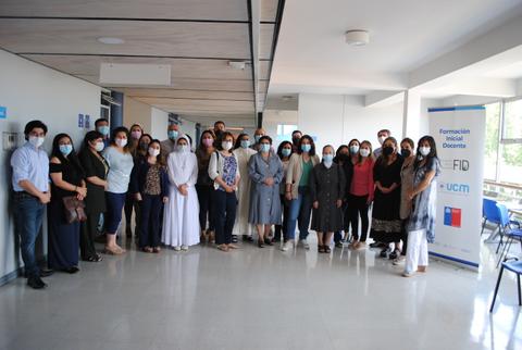 Un grupo de personas con mascarillas se reúne en un pasillo dentro de un edificio.