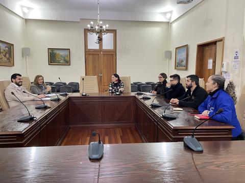 Reunión en una sala de conferencias con varias personas sentadas alrededor de una mesa.