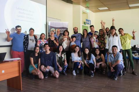 Grupo de personas posando sonrientes en un taller sobre diseño para el cambio climático.