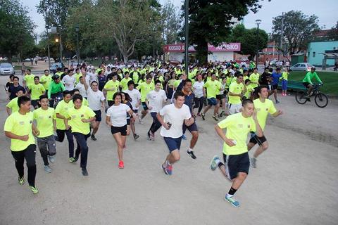 Un grupo grande de personas corriendo en un parque durante un evento deportivo.